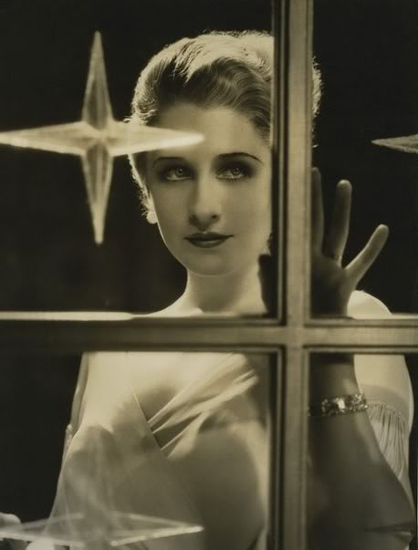 1930s movie star Norma Shearer gazes wistfully out a Christmas window.